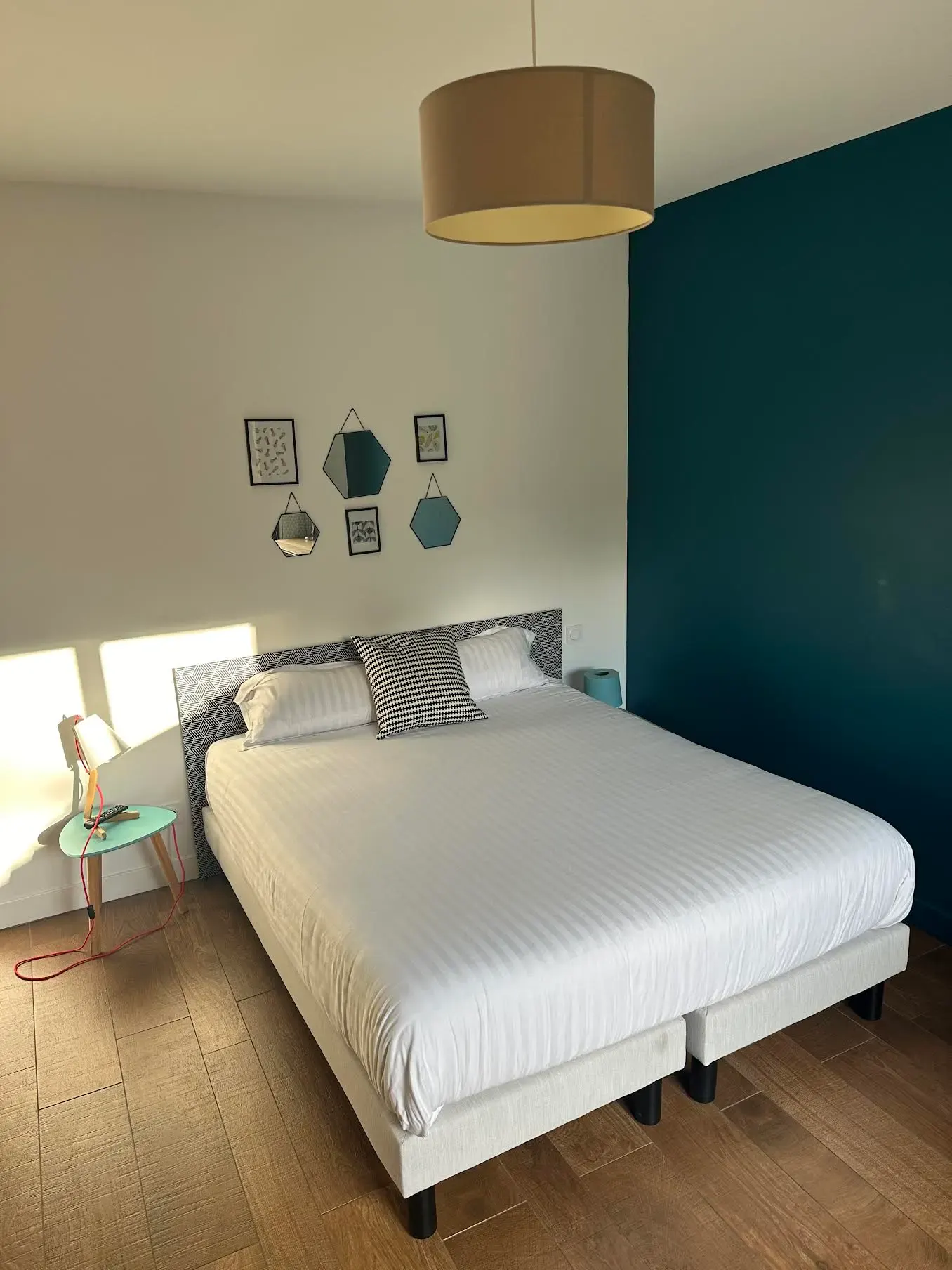 Chambre Heidelberg : lit double, mur bleu canard et décoration murale en hexagones