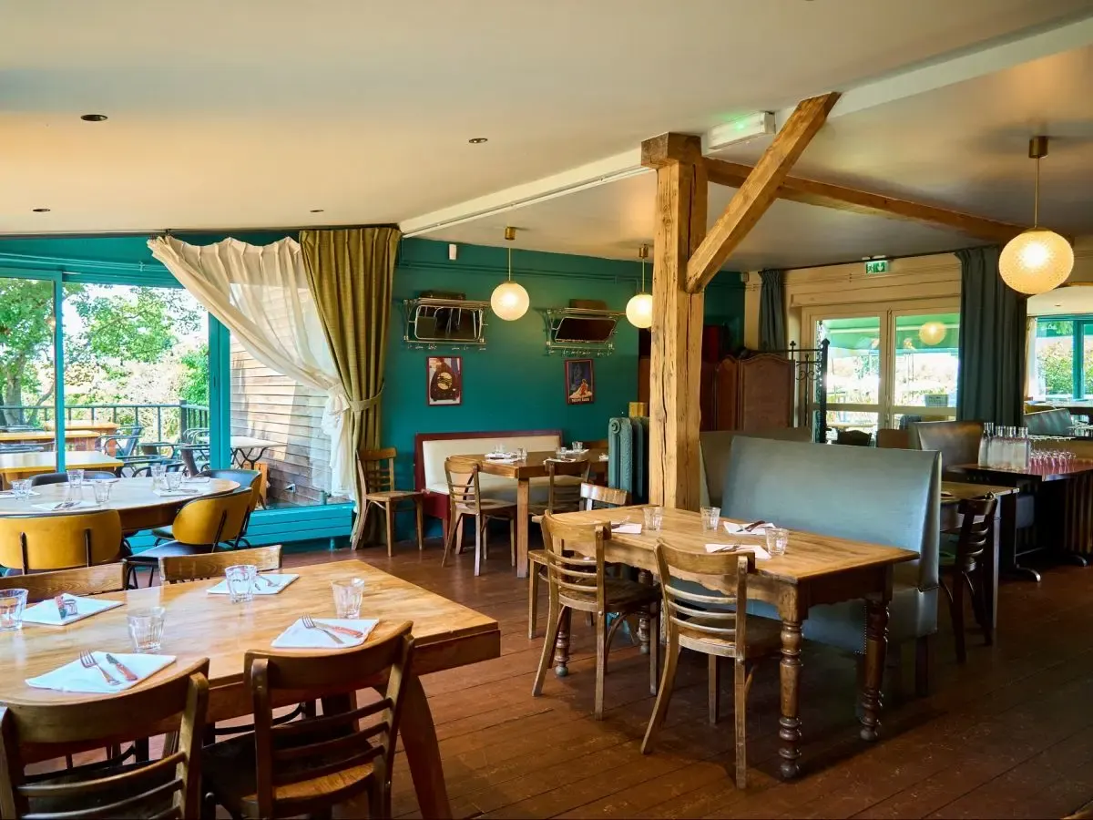 Dining room of Là-Haut sur la Colline: turquoise walls, wooden beams and large windows