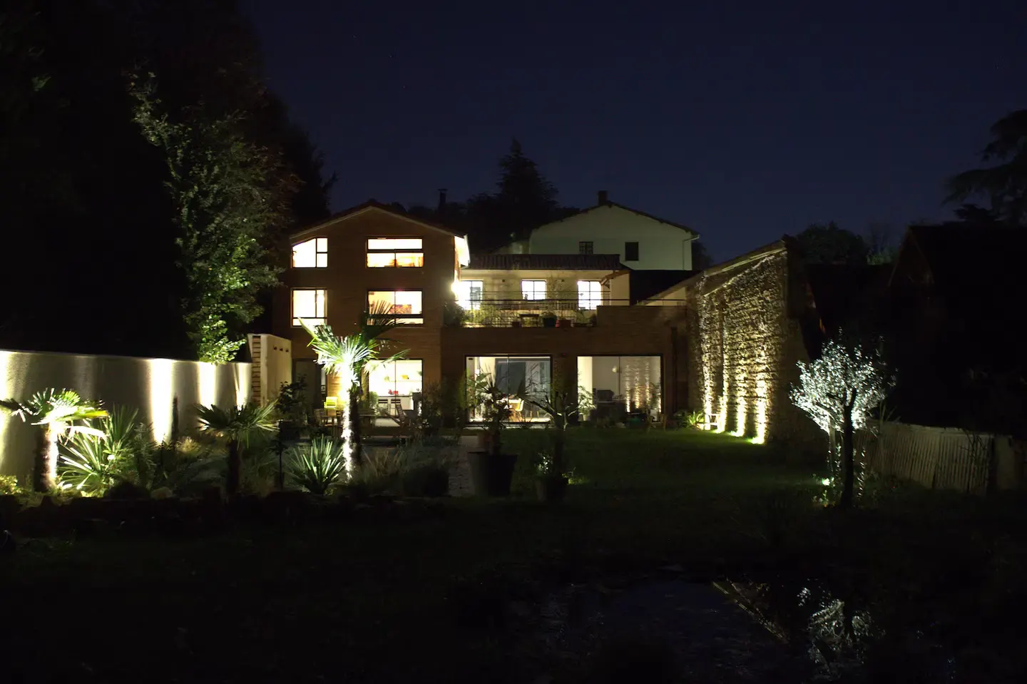 La maison et le jardin éclairés de nuit