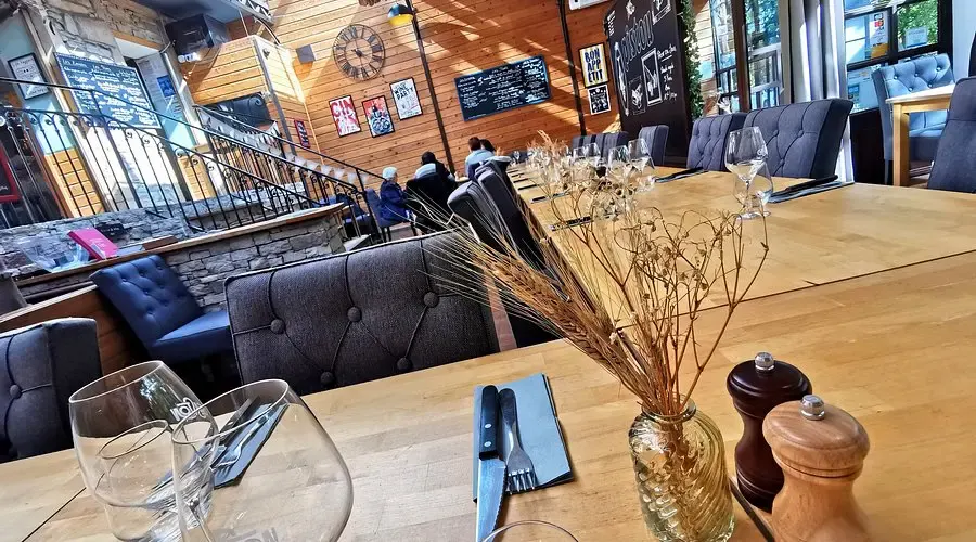 Table laid in Pistou's dining room, glasses, pepper mill and dried flower bouquet